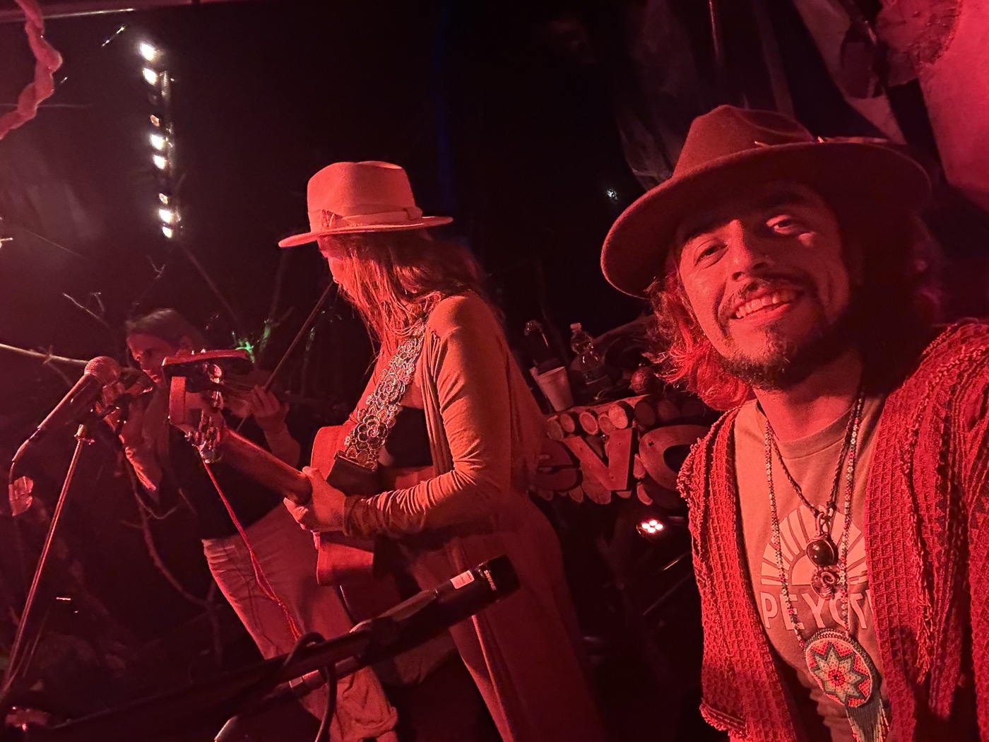 Ro in a hat on a stage in red light